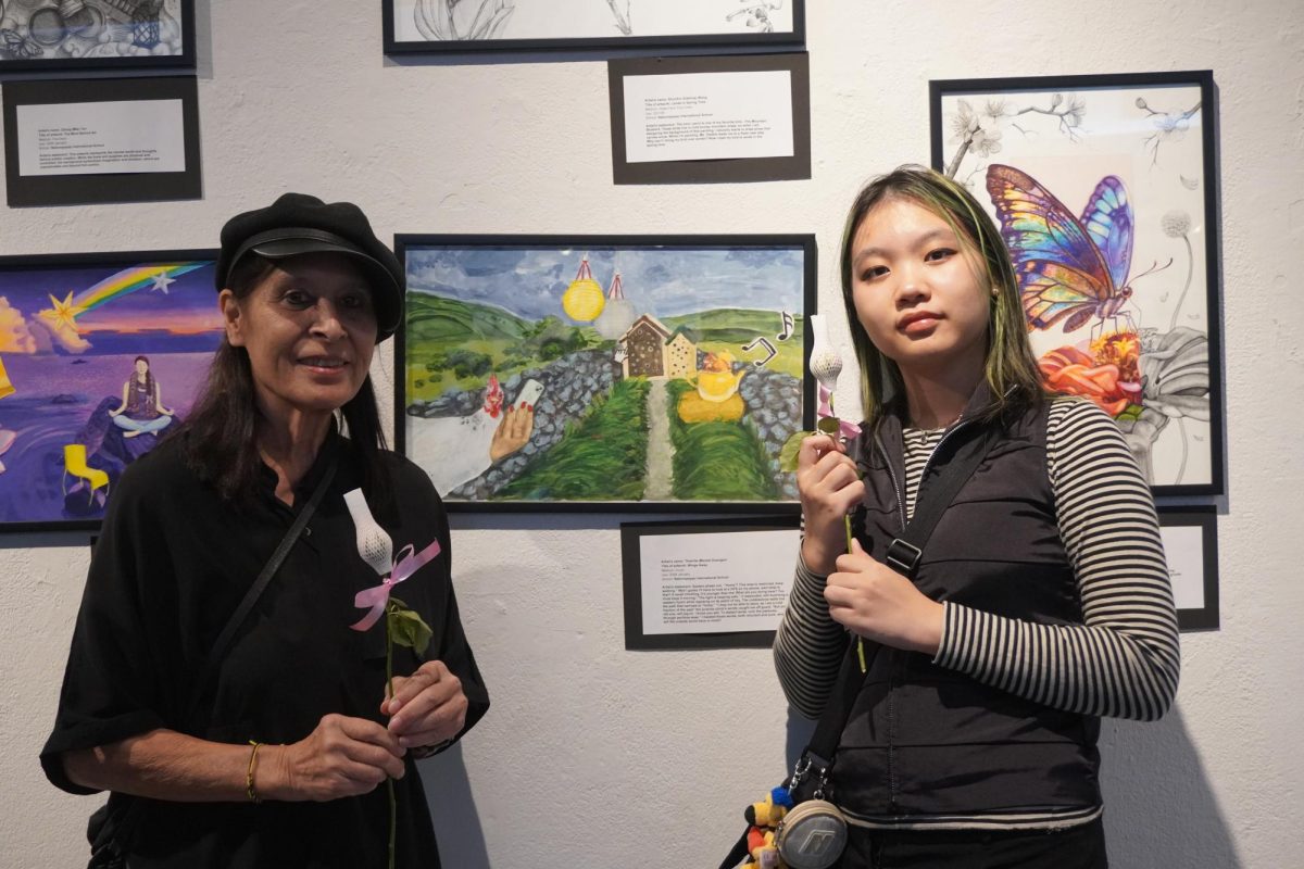 Ms. Debbie poses with pride alongside artist and ninth grader Monet.  Monet's featured piece is called "Wing's Away"